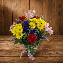 Colorful bouquet of daisies, carnations, and alstroemeria in a glass vase