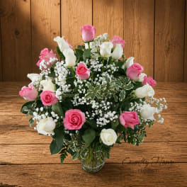 Pink and white roses arranged in a clear glass vase