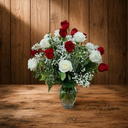 Red and white roses arranged in a clear glass vase