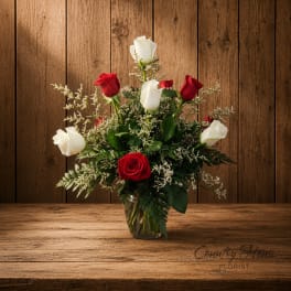 Red and white roses arranged in a clear glass vase