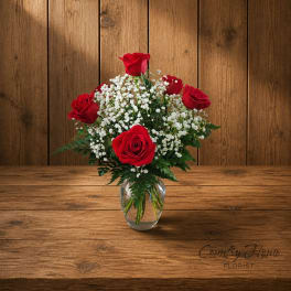 Red roses and white baby's breath in a clear glass vase