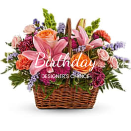 Mixed pink and orange flowers in a wicker basket