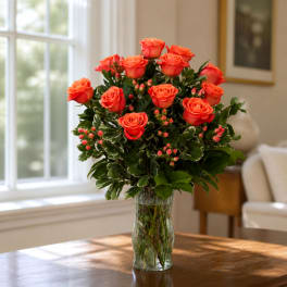 Orange roses arranged in a clear glass vase