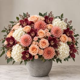 Peach roses, burgundy orchids, and white hydrangeas in a gray vase