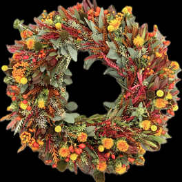Autumn wreath with orange and yellow flowers and mixed foliage