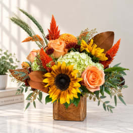 Sunflower and rose arrangement in a wooden cube vase