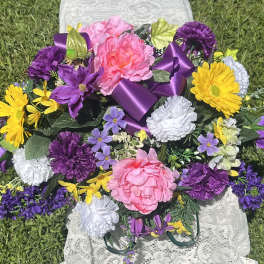 Colorful bouquet with pink, purple, yellow, and white flowers tied with a purple ribbon