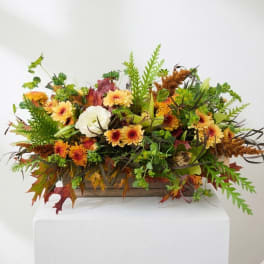 Autumn floral arrangement with yellow daisies in a wooden box