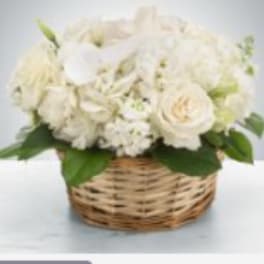 White flower arrangement in a wicker basket