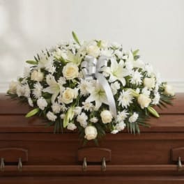 White floral casket spray with roses and lilies