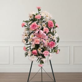 Pink and white floral standing spray on an easel with a ribbon