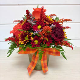 Autumn bouquet of red and orange flowers in a vase with plaid ribbon