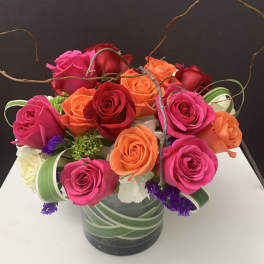 Mixed roses in a glass vase with curly branches