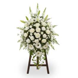 White floral standing spray on a wooden easel