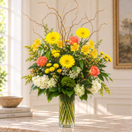 Yellow and coral mixed bouquet in a clear glass vase