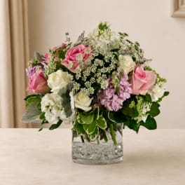 Pink and white rose bouquet in a clear glass vase