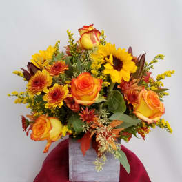 Orange and yellow bouquet in a square gray vase
