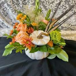 Pumpkin-shaped floral arrangement with peach roses and orange mums