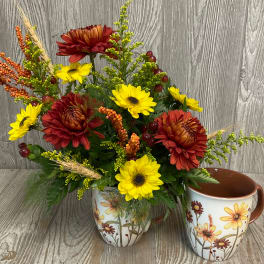 Fall floral arrangement in a floral ceramic mug beside a matching cup