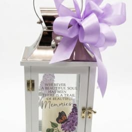 White memorial lantern with a purple ribbon bow and printed candle inside