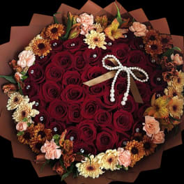 Heart-shaped bouquet of red roses with peach and yellow flowers