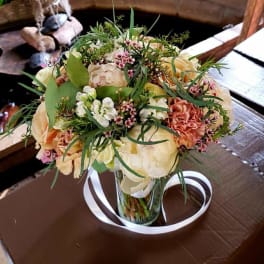 Bouquet of peach and white flowers in a clear glass vase
