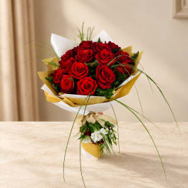 Bouquet of red roses wrapped in white and gold paper