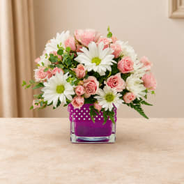 Pink roses and white daisies in a purple square vase