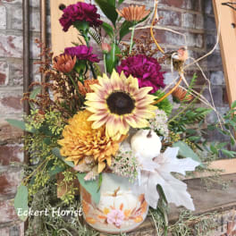 Autumn floral arrangement in a painted pumpkin vase with sunflowers and mums