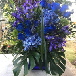 Blue and purple floral arrangement with roses, hydrangeas, and irises