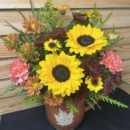Sunflower and chrysanthemum arrangement in a brown ceramic vase