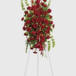Tall standing spray of red roses on a metal easel