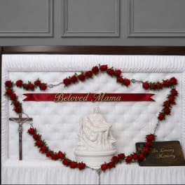 Red rose funeral casket spray with memorial ribbon and crucifix