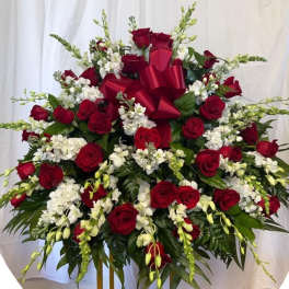 Large red rose and white flower arrangement with a red bow