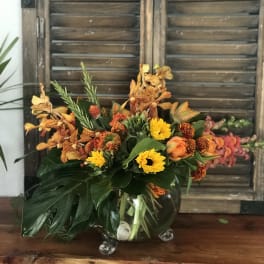 Orange and yellow floral arrangement in a clear glass vase