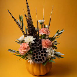 Pumpkin arrangement with peach and white flowers in a pumpkin vase