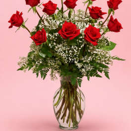 Red roses arranged in a clear glass vase