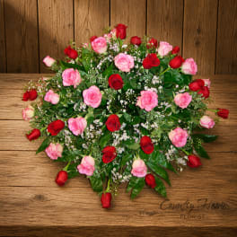 Pink and red rose bouquet with baby's breath on a wooden table