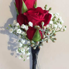 Red rose boutonniere with white baby's breath and black ribbon