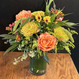 Orange roses and yellow chrysanthemums in a glass vase