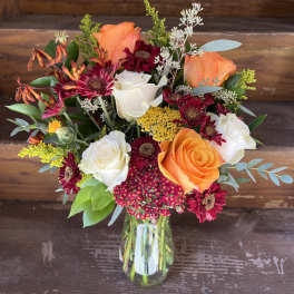 Mixed bouquet of orange and white roses in a glass vase