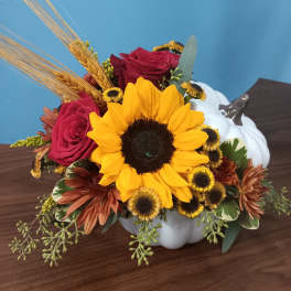 Sunflower and rose arrangement in a white pumpkin container