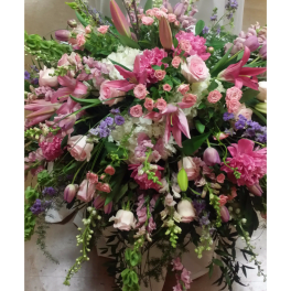 Large pink and white floral arrangement in a white container