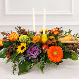 Autumn floral centerpiece with two white taper candles