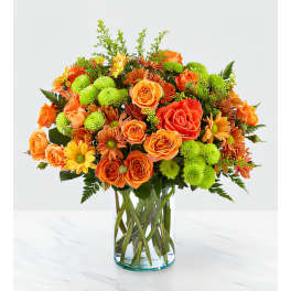 Orange and yellow mixed flower bouquet in a clear glass vase