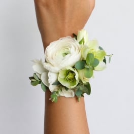 White and pale green wrist corsage with flowers and greenery