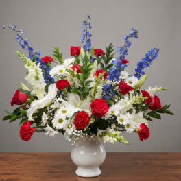 Red, white, and blue mixed bouquet in a white vase