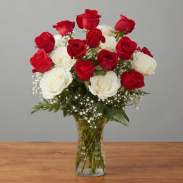 Red and white roses arranged in a clear glass vase