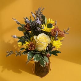 Yellow and brown mixed bouquet in a glass vase