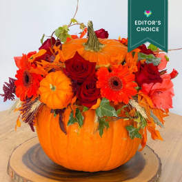 Pumpkin centerpiece with red roses and orange gerbera daisies